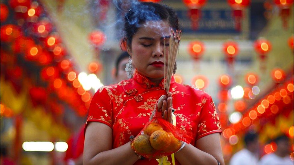 Worshippers burn incense in prayer at a temple to celebrate the Lunar New Year, or Spring Festival, in Chinatown in Bangkok, Thailand