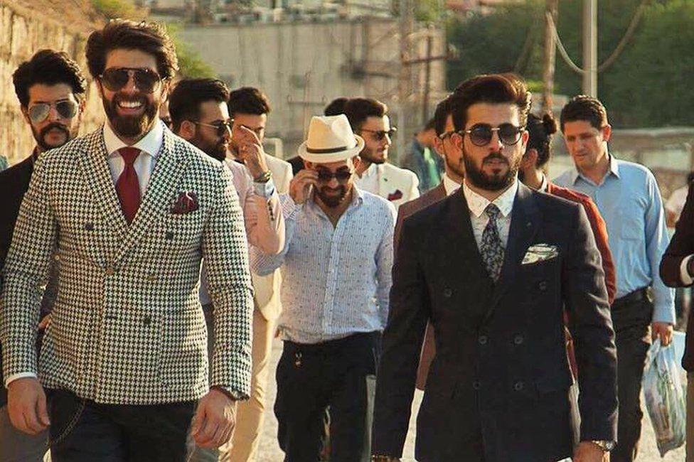 Iraqi men walking down a street in suits