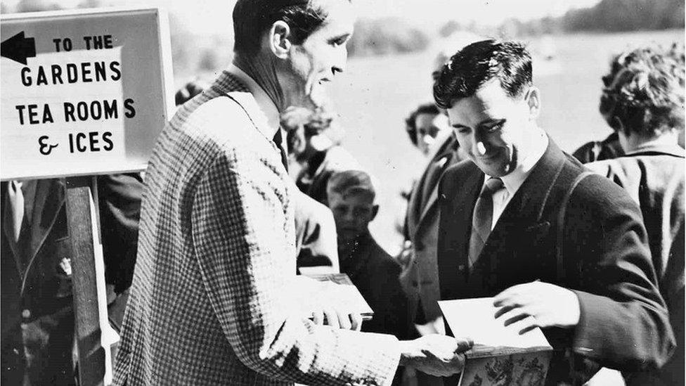 B&w photo of the 6th Marquess selling programmes at Longleat