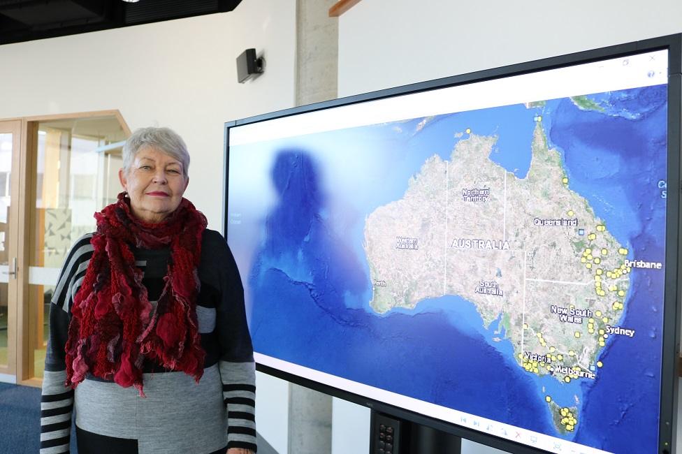 Professor Lyndall Ryan with a screen showing a map of Australia's frontier massacres