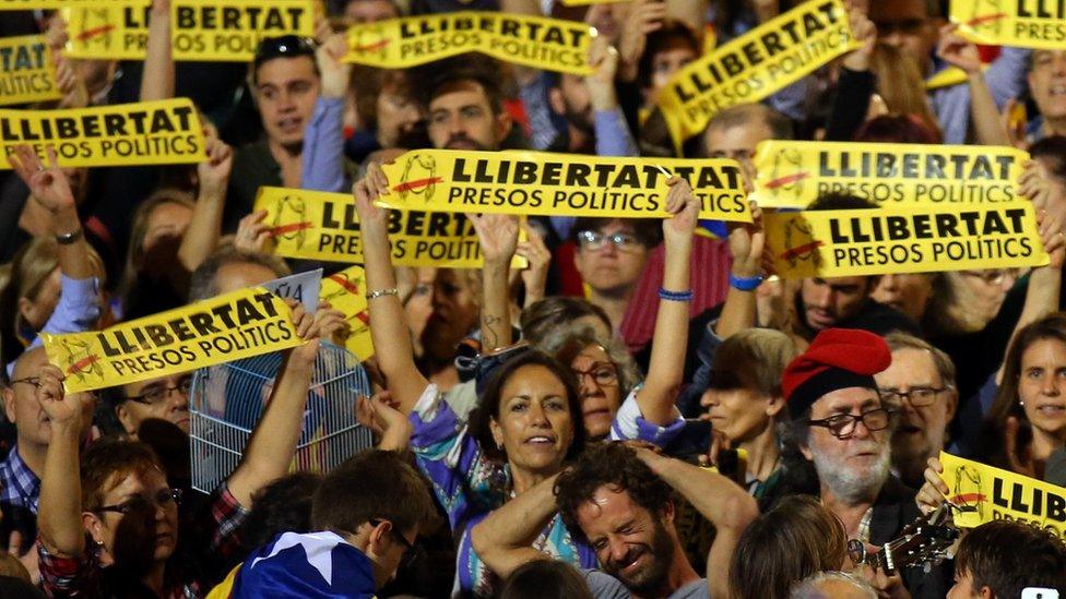 People hold banners reading "Freedom political prisoners" at a protest in support of detained Catalan ex-ministers in Barcelona