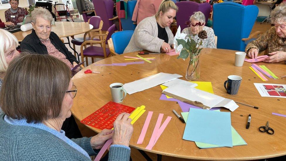 People doing crafts sat around a table