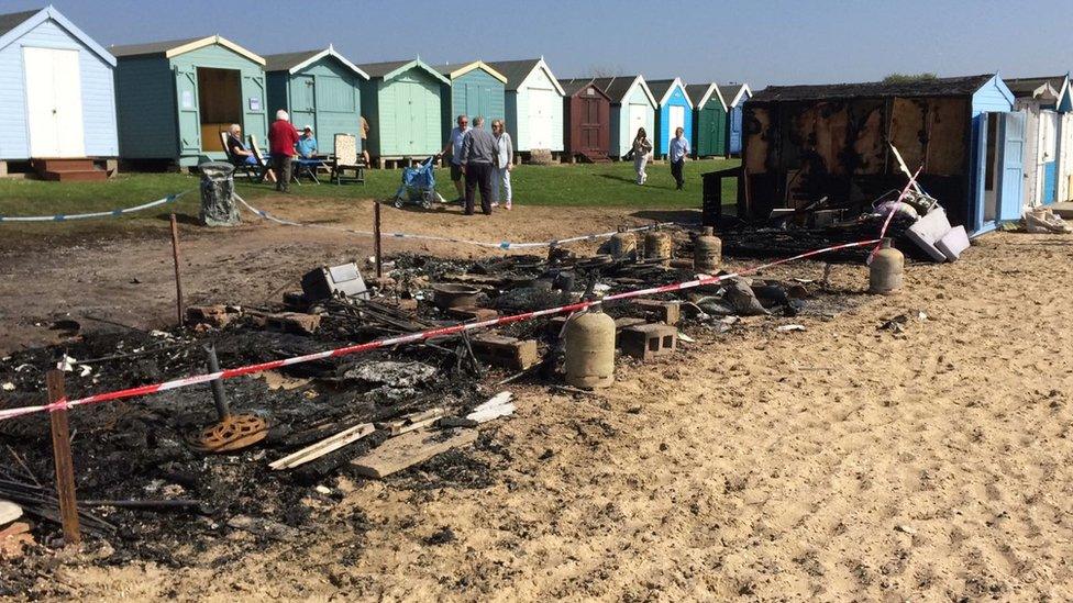 Burnt-out beach huts on Mersea Island.