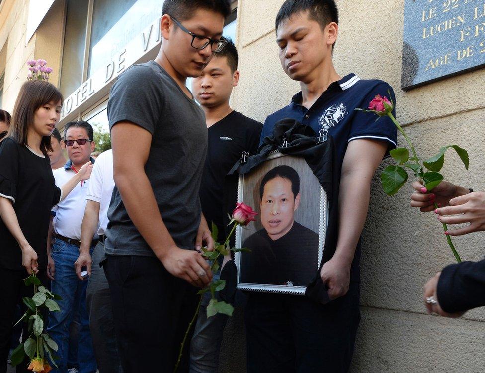 Family members and relatives hold a portrait of Zhang Chaolin outside the town hall in Aubervilliers, north-eastern suburbs of Paris, 14 August