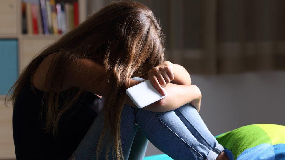 A stressed teenager with a mobile phone