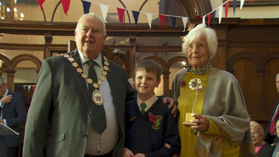 Maureen Lightbody, holding her silver poppy, with Mayor Bill Keery and a schoolboy from Bangor