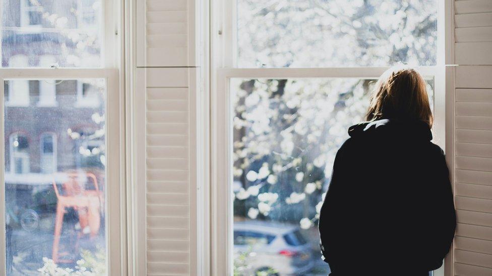 A woman standing at a window (file image)