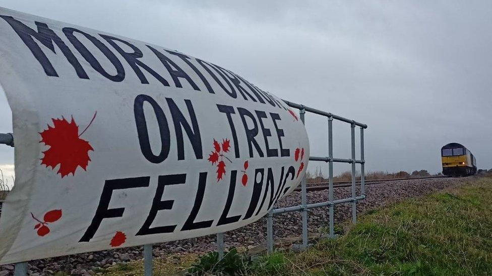 Protest banner attached to railings with train in the background