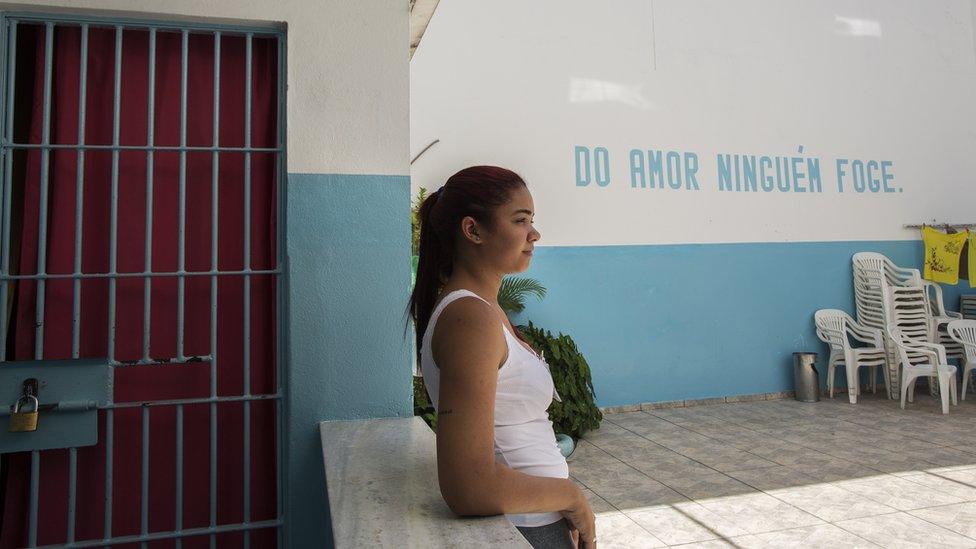 Tatiane Correia de Lima leans against a wall in the courtyard