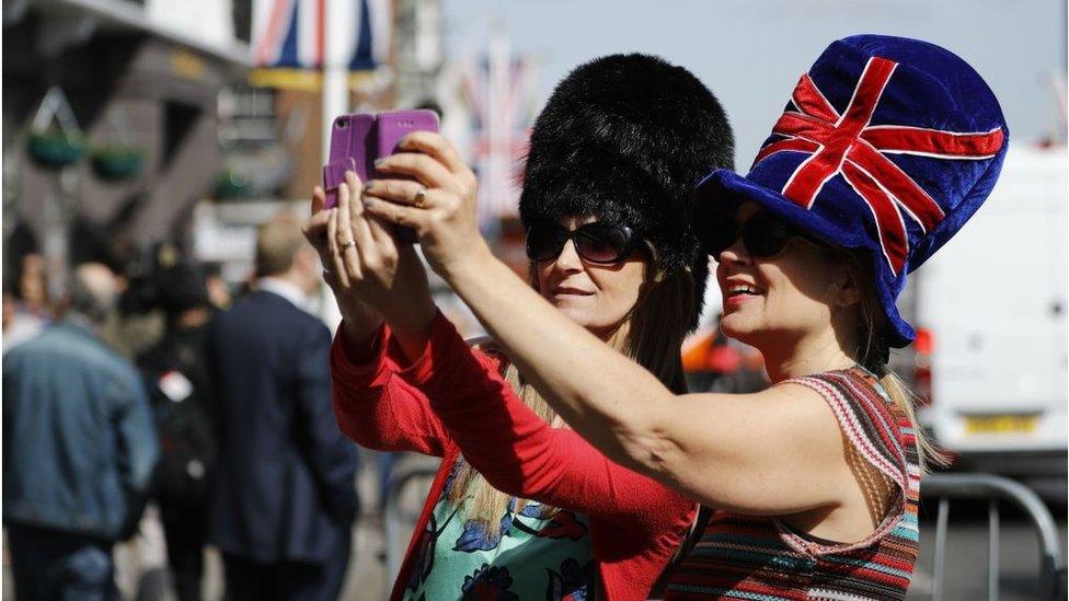 Visitors take a selfie photograph near Windsor Castle in Windsor on May 18, 2018