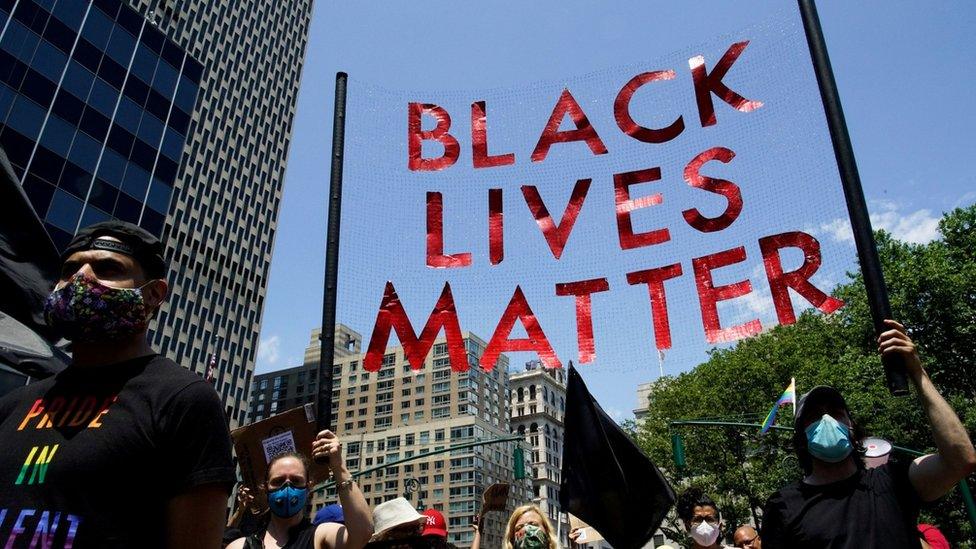 People hold a sign as they take part in a joint LGBTQ and Black Lives Matter march on the 51st anniversary of the Stonewall riots in New York City, New York, U.S. June 28, 2020.