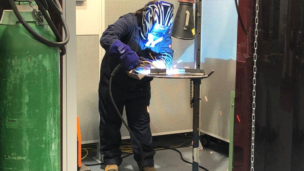 Woman welding in protective gear