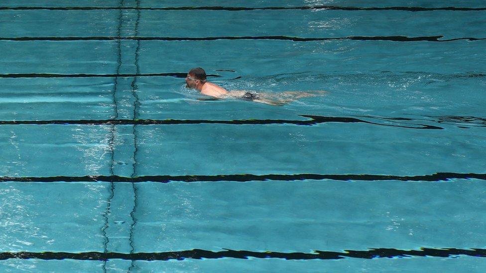 Man swimming in an empty pool