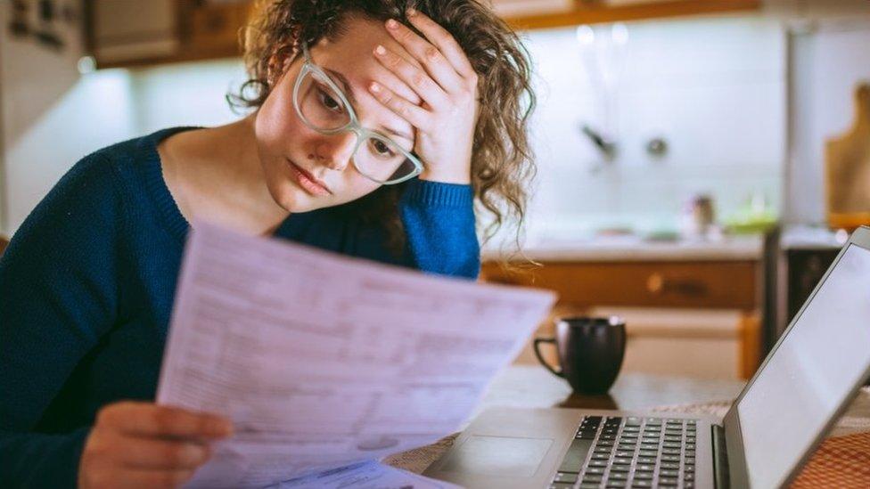 Woman at desk with bill