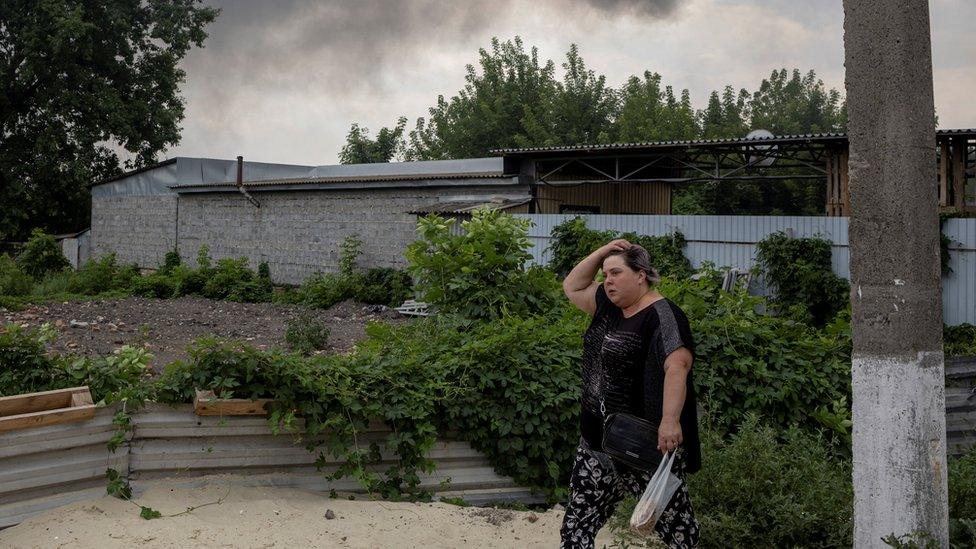 A woman walks past the market after shelling in Slovyansk