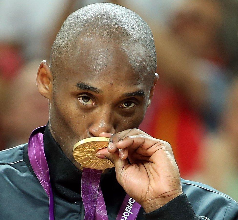 Kobe Bryant kissing gold medal at the Olympics.