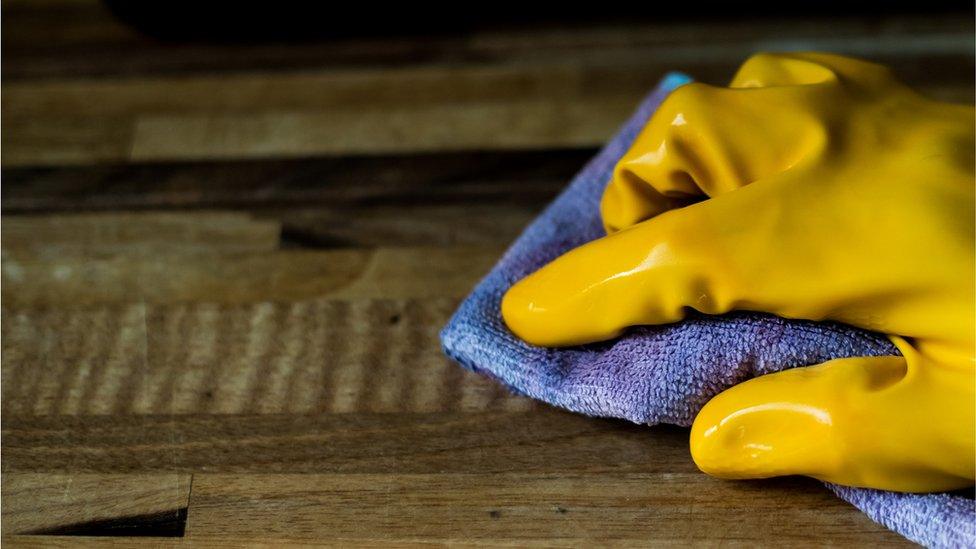 A PERSON CLEANING A DESK