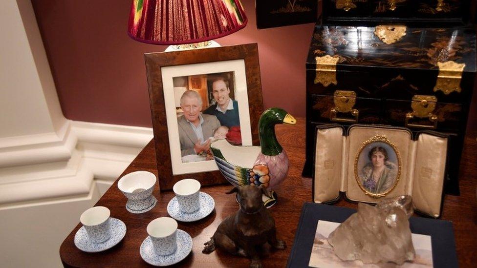 a side table with ornaments and photographs in the exhibition