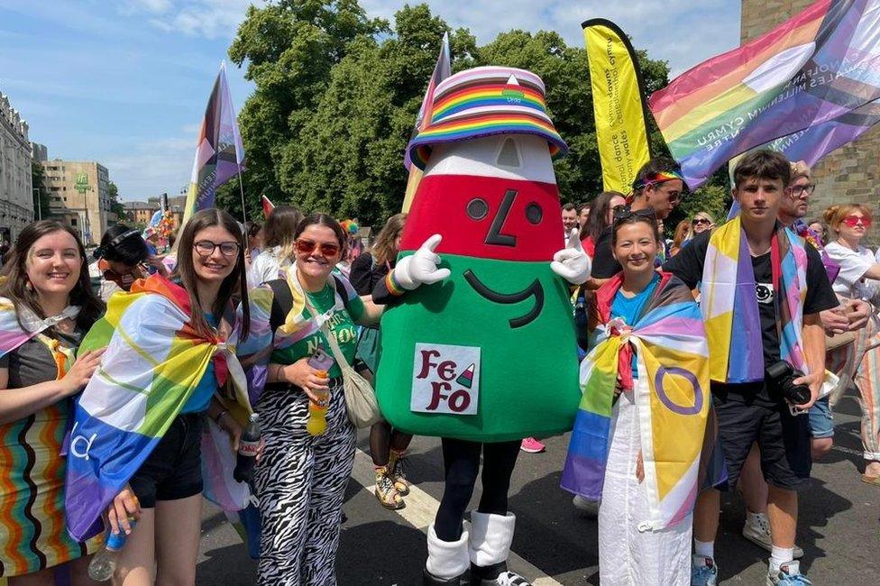 Roedd Mistar Urdd yn gorymdeithio yn ei het amryliw