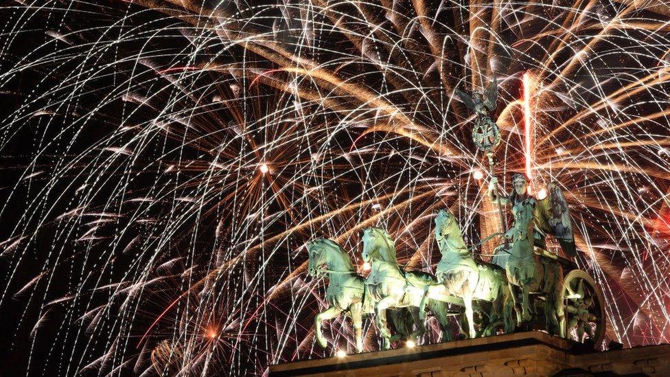 Fireworks explode over the Brandenburg Gate at midnight