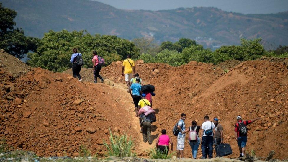 People cross from Venezuela through "trochas" - illegal trails- near the Simon Bolivar International Bridge