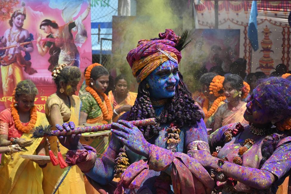 Youths smeared in coloured powder and dressed as Lord Krishna and deity Radha celebrate the Holi festival, the Hindu spring festival of colours, in Kolkata, India.