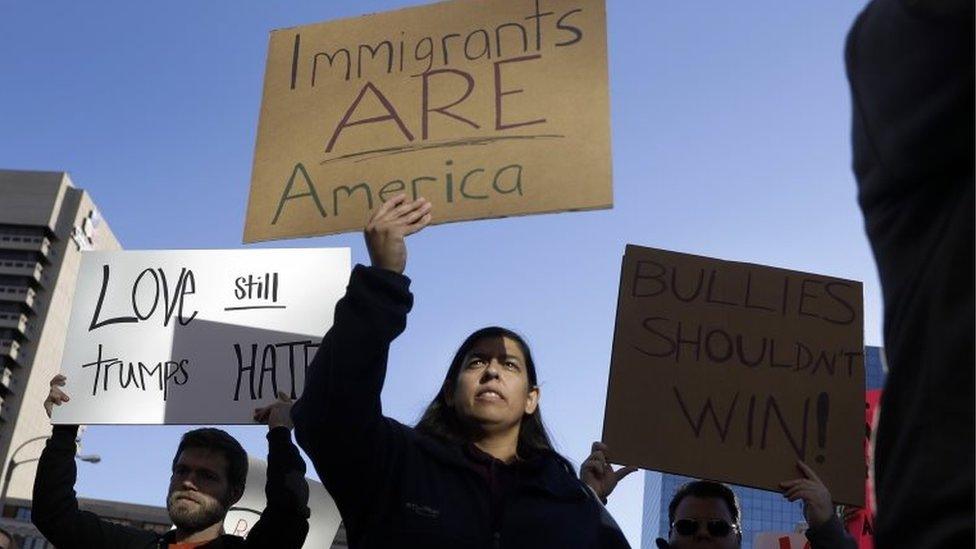 Protesters hold signs as they march in opposition to the election of President-elect Donald Trump on Sunday, Nov. 13, 2016, in St. Louis.