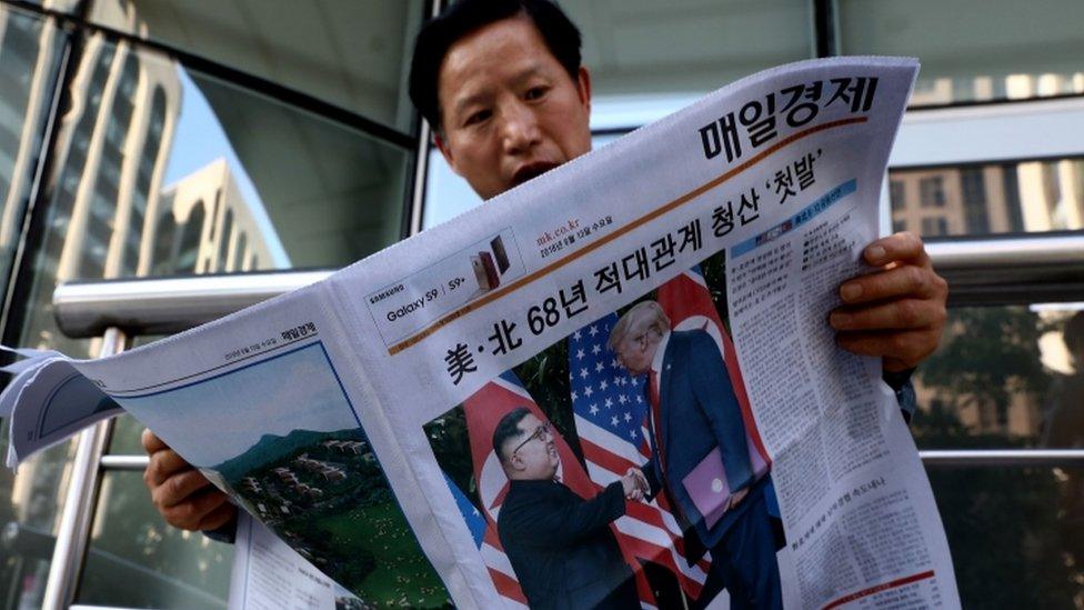 A man in South Korea reads a newspaper carrying images of the summit