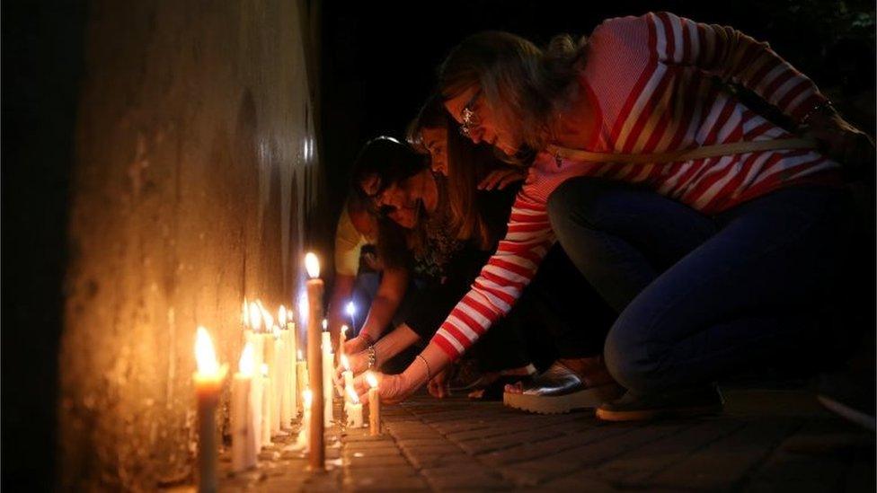 People place candles outside the Instituto Politecnico, a technical high school, where the five Argentine citizens who were killed in the truck attack in New York on October 31 went to school, in Rosario, Argentina November 1, 2017