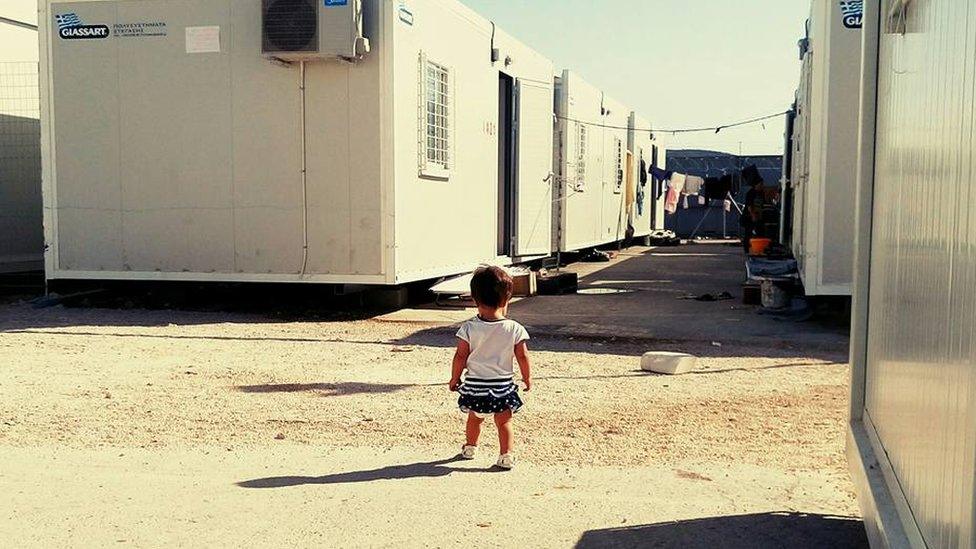 Lina's two-year-old daughter outside their shelter in Greece