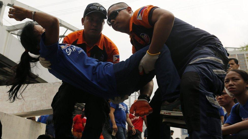 Filipino rescuers carry a mock victim during an earthquake preparedness drill in Makati city, south of Manila, Philippines, 22 June 2016.