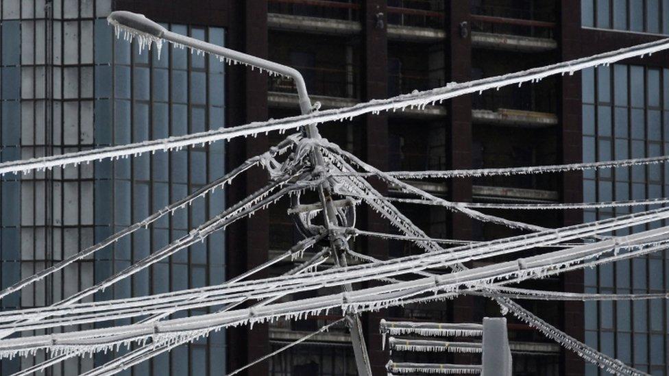 Ice-covered power lines and a light pole are pictured after freezing rain in the far eastern city of Vladivostok, Russia