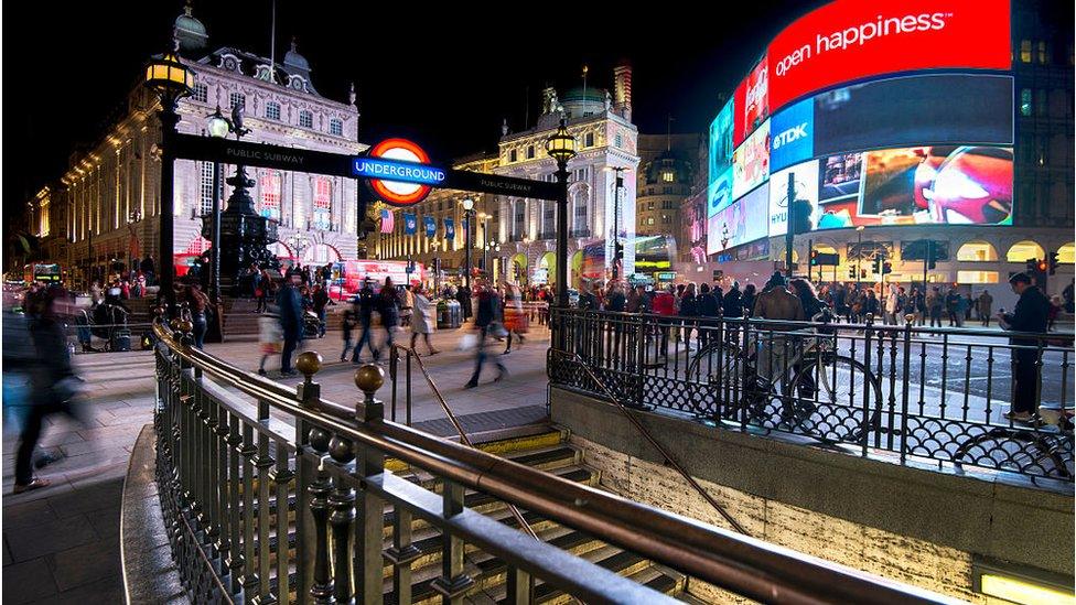 Pedestrians and traffic outside Piccadilly Circus tube station in London.