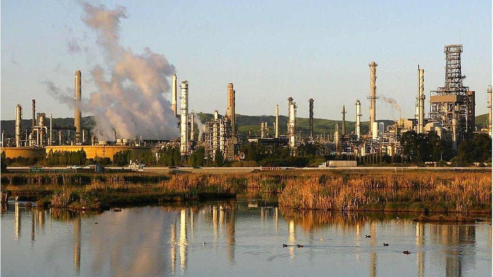 Smoke drifts away from a Shell Oil refinery