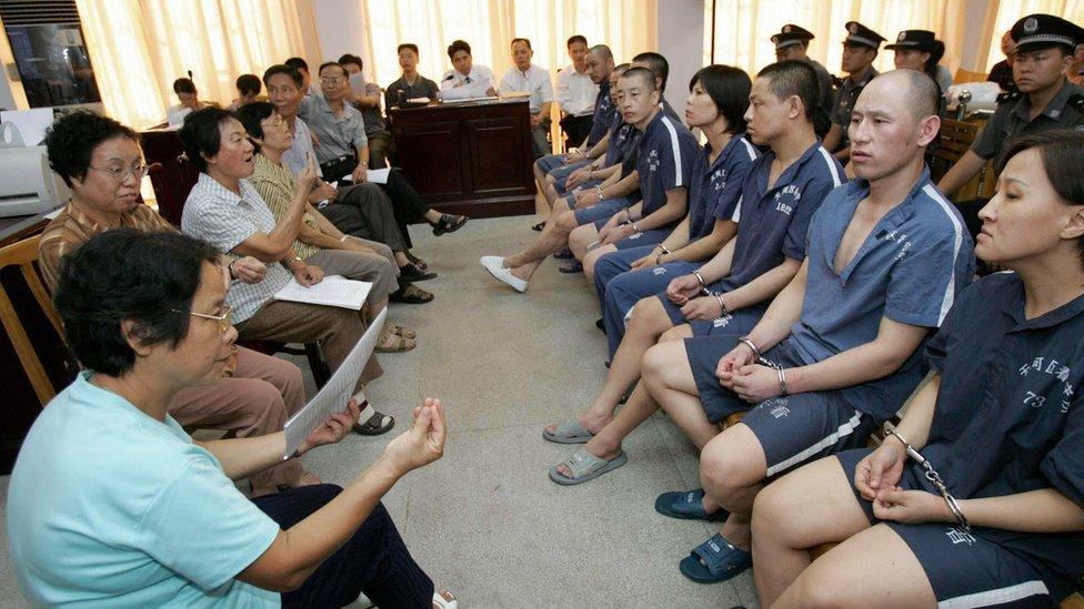 Deaf prisoners at a courtroom, facing sign language interpreters