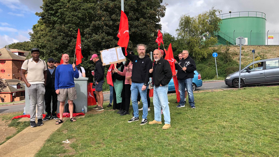 Workers standing on grass striking