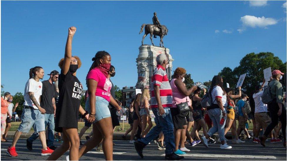 Black Lives Matter activists occupy the traffic circle underneath the statue of Confederate General Robert Lee, now covered in graffiti