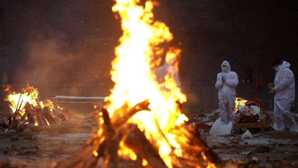 Relatives of coronavirus (Covid-19) victims perform the last rites, during a cremation, at a crematorium in New Delhi, India on May 09, 2021.