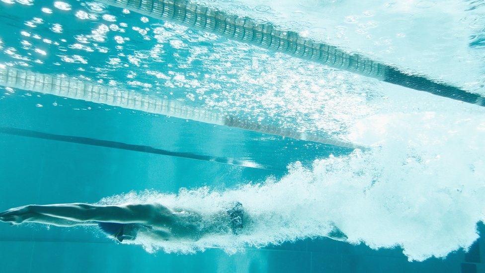 A woman using an indoor swimming pool