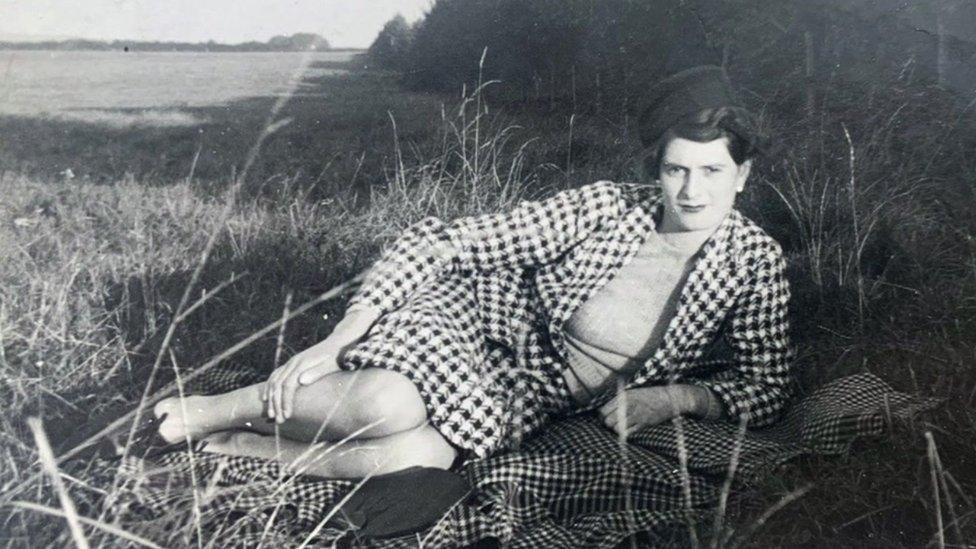 Kathleen as a young woman lying on the grass