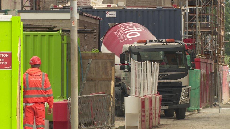 A cement mixer and a builder on a building site