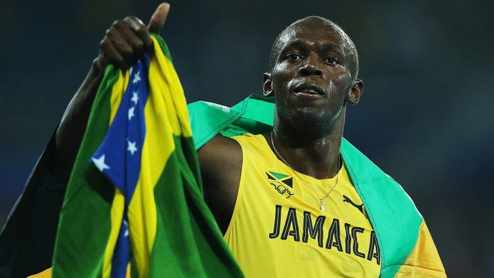 A photo of Usain Bolt draped in a Jamaican flag