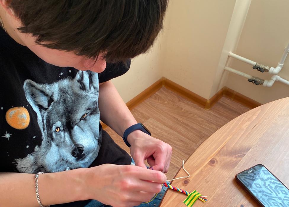 Nina weaving a friendship bracelet