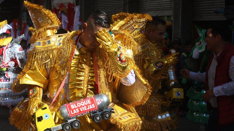 A man touches his brow as he takes part in the parade.