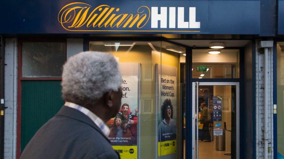 Man looking at William Hill shopfront