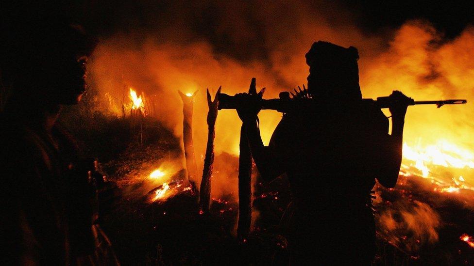 An armed Sudanese rebel from the Justice and Equality Movement (JEM) arrives at the abandoned village of Chero Kasi less than an hour after Janjaweed militiamen set it ablaze in the violence plagued Darfur region September 7, 2004.