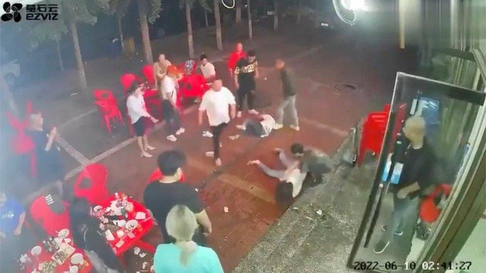 Two women lie on the ground after being assaulted by a group of men outside a restaurant in the northeastern city of Tangshan, China, June 10, 2022, in this screen grab taken from surveillance footage obtained by REUTERS on June 12, 2022.