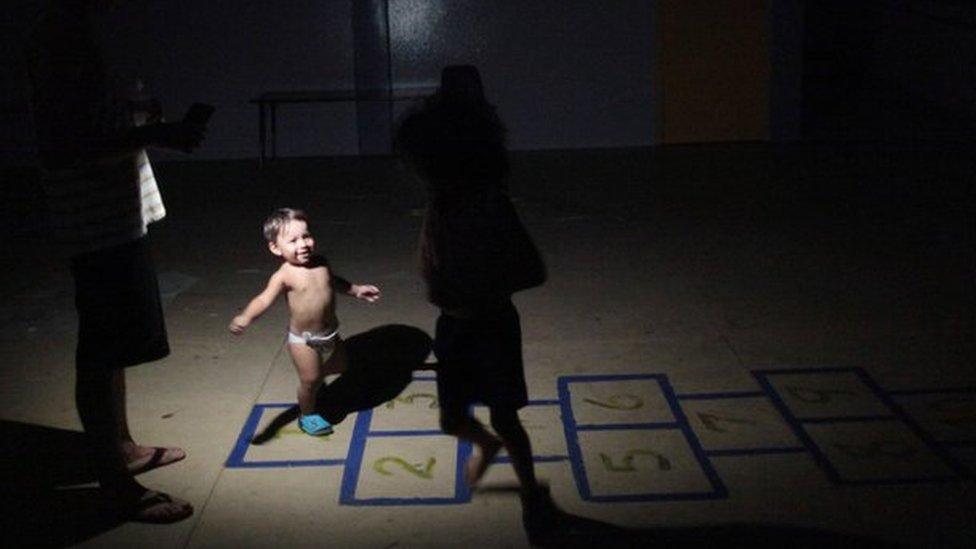 A child barely visible under the light of a torch