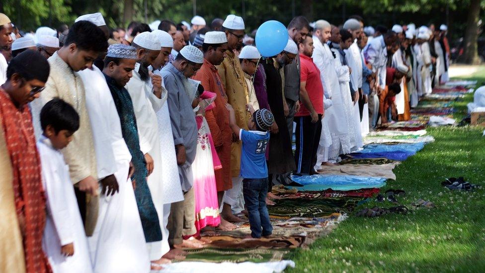 Muslim faithfuls take part in a special morning prayer to start their Eid al-Fitr celebrations on a field at the Prospect Park in Brooklyn borough of New York on July 17, 2015