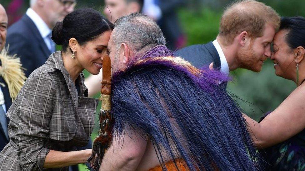 Prince Harry and his wife Meghan, the Duchess of Sussex, receive a "hongi", or traditional Maori greeting from elders